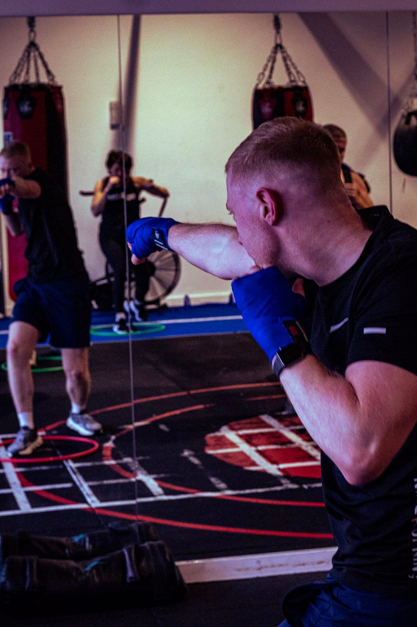 A member in hand wraps shadow boxing in front of the mirror