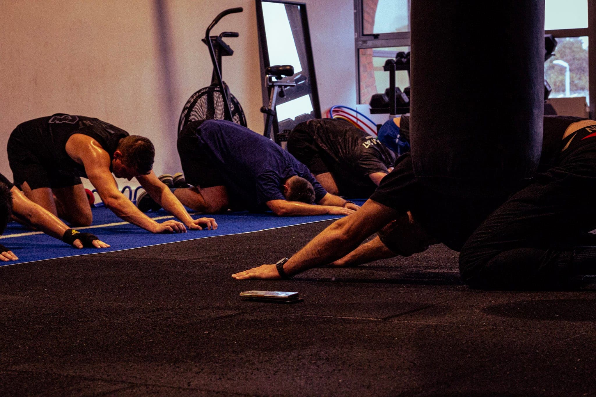 Members stretching on the mats after a session