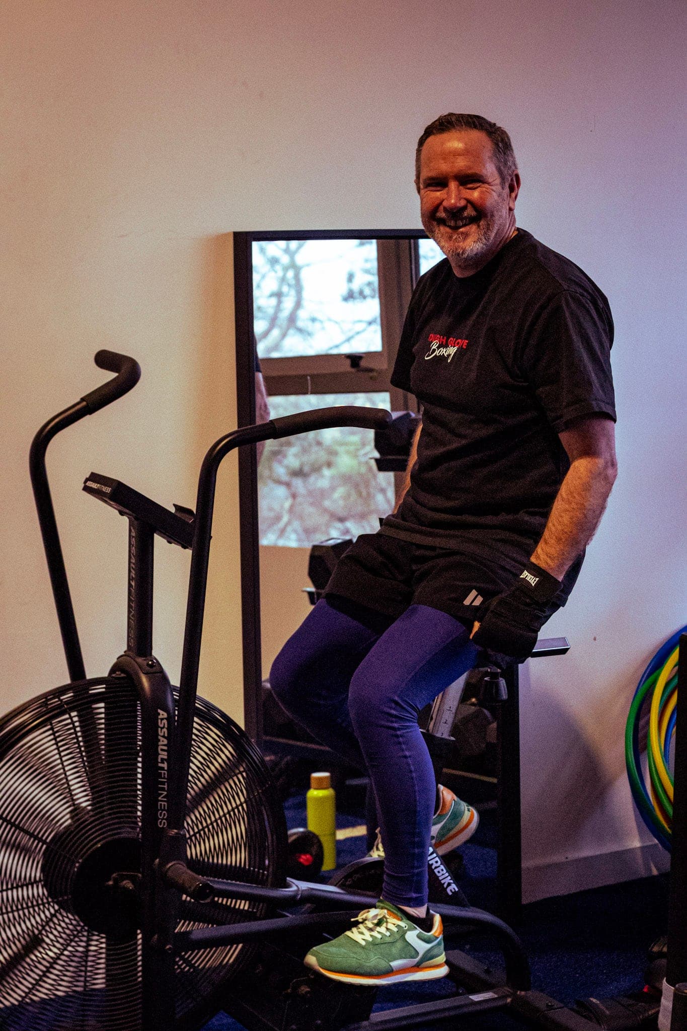 A smiling member taking a break on the air bike