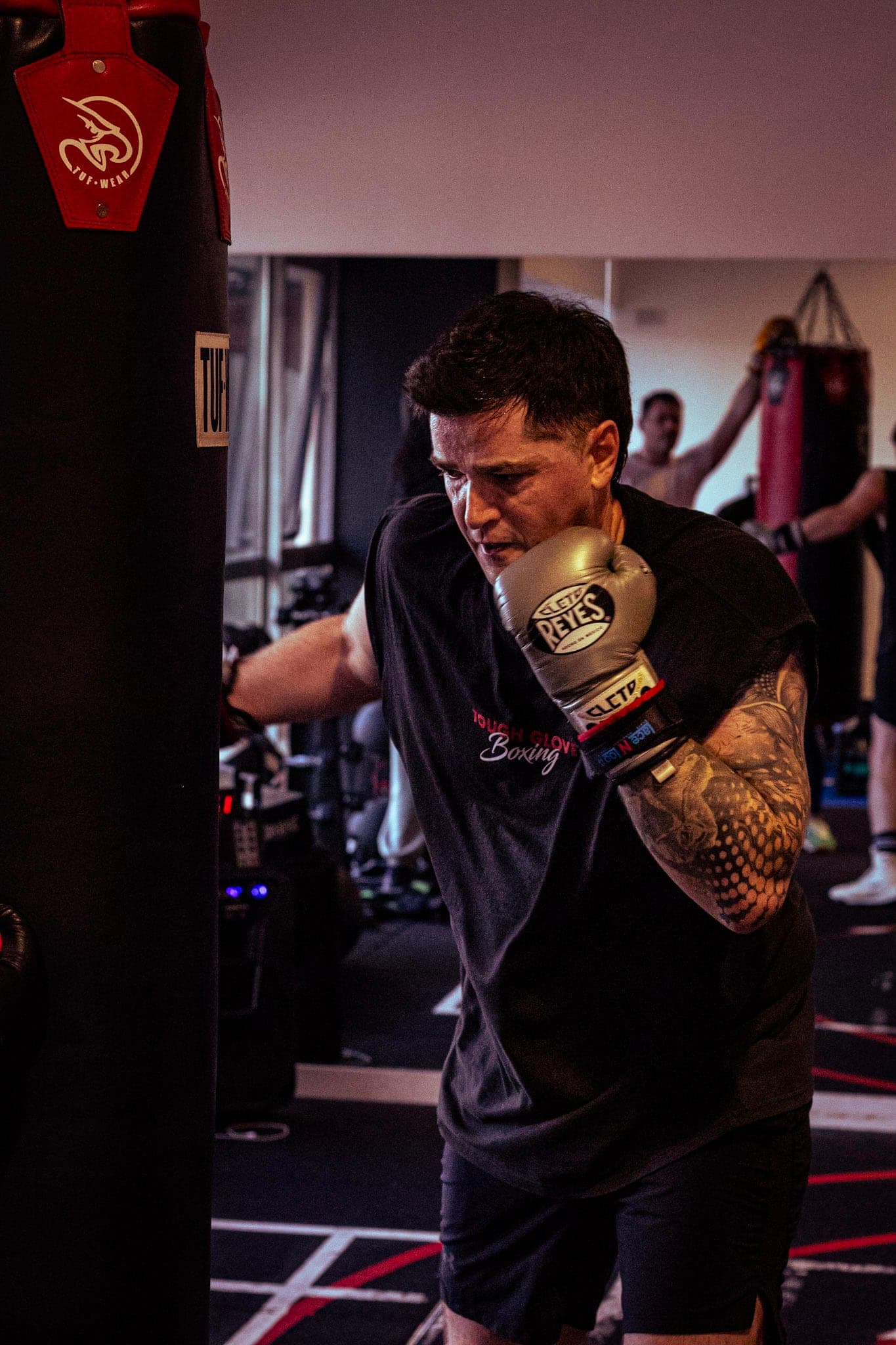 A member in boxing gloves working the heavy bag