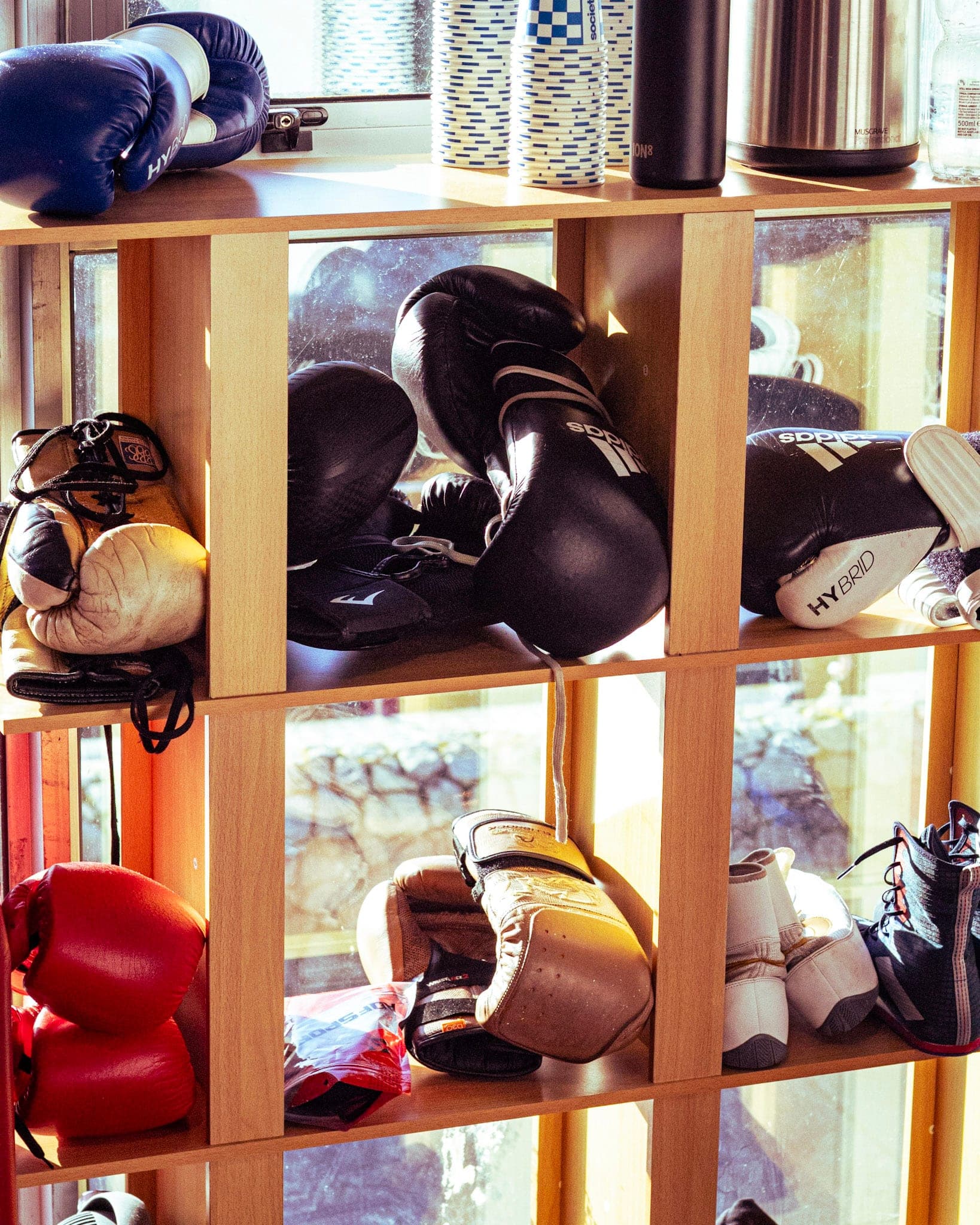 Boxing gloves and headguards on the gym's shelves
