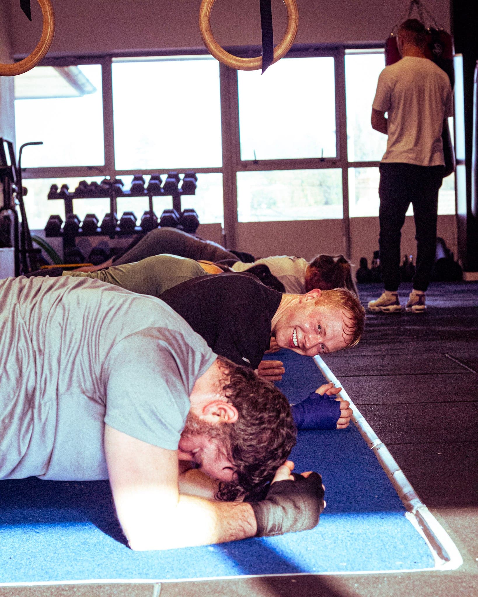 Members laughing while holding a plank
